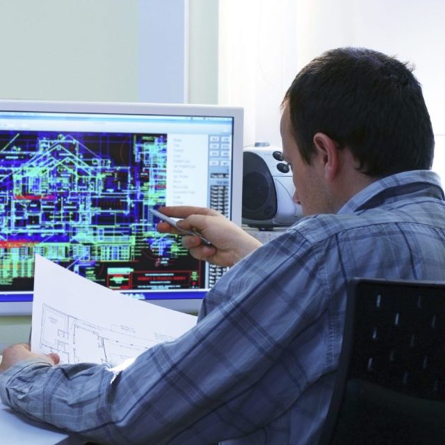 Mann zeigt auf einen Computerbildschirm mit technischen Plänen.