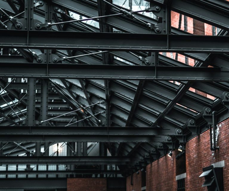 Industrieller Innenraum mit freiliegenden Metallträgern und Backsteinwänden.