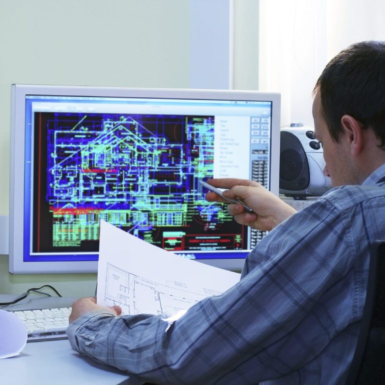 Mann analysiert technische Pläne an einem Computerbildschirm.